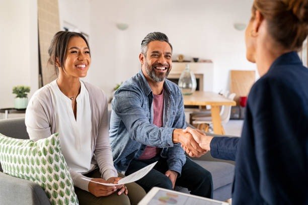 Loan advisor shaking hands with happy clients